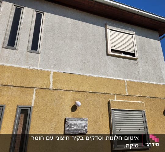 קיר חיצוני עם חלונות ותריסים סגורים